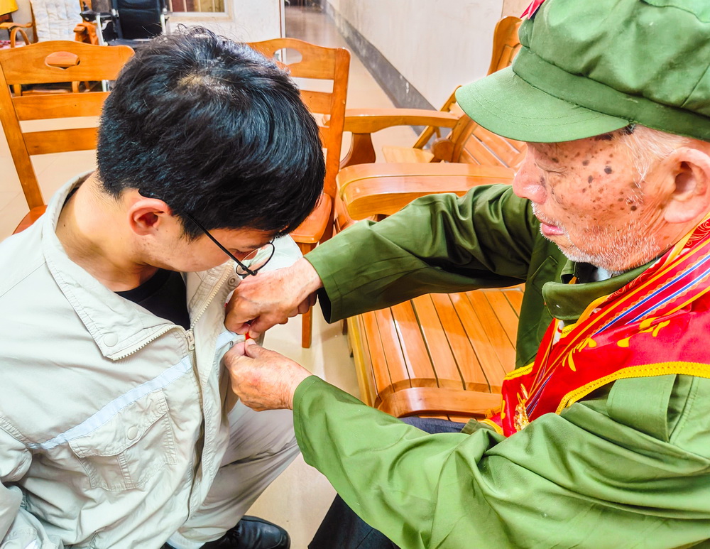 2、韋仕隆給新入黨的青年黨員佩戴黨章--李陽攝.jpg